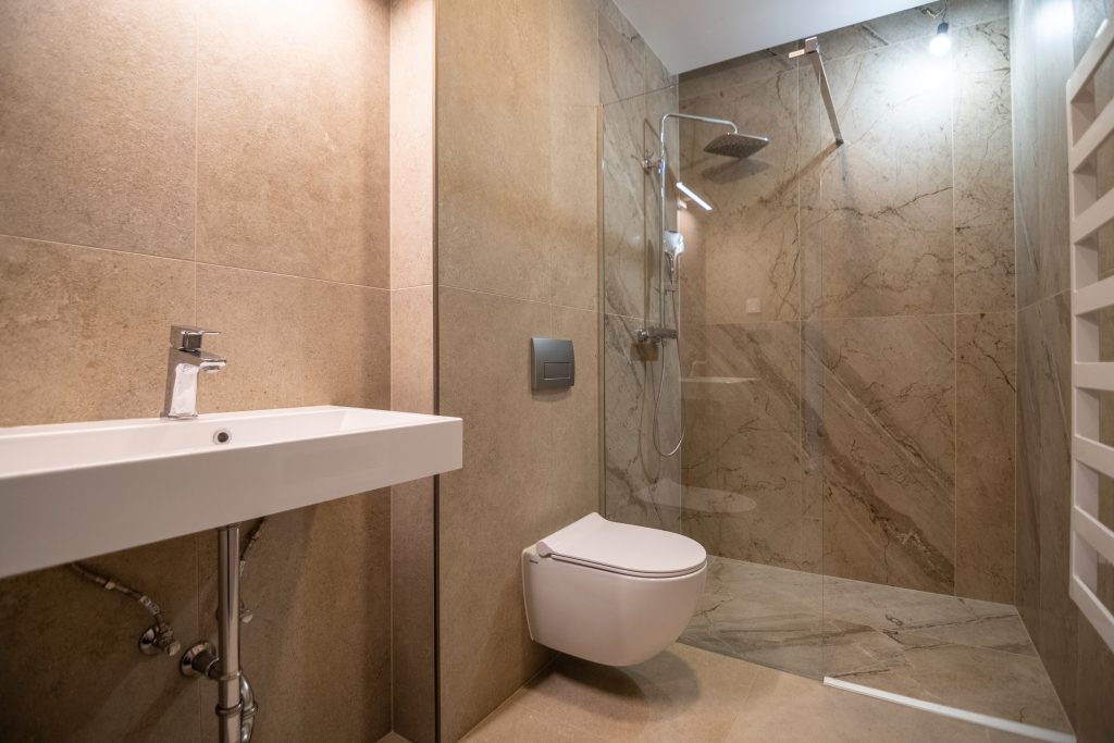 Modern fürdőszoba zuhanyzóval és fali WC-vel a Coloman Residence siófoki lakásában.